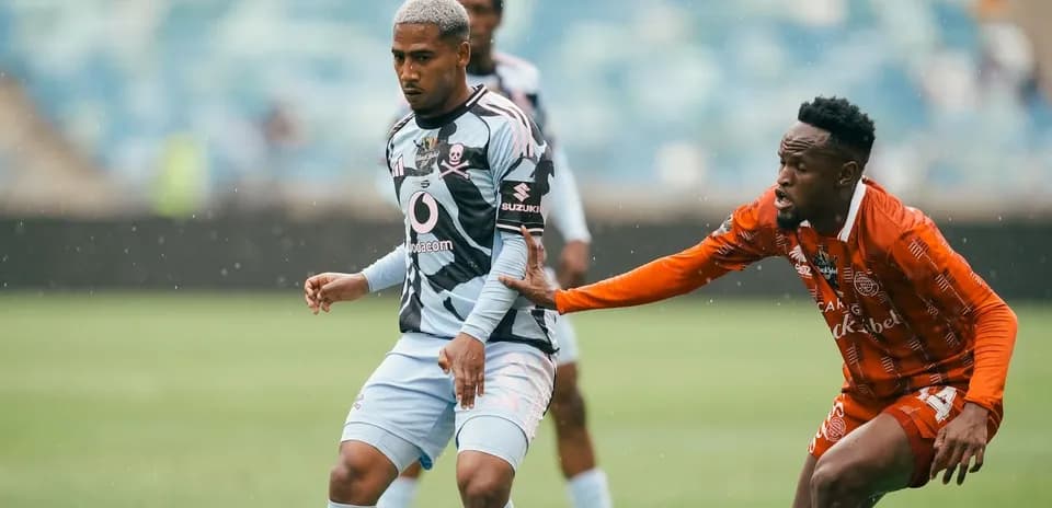Two players competing for the ball in rain