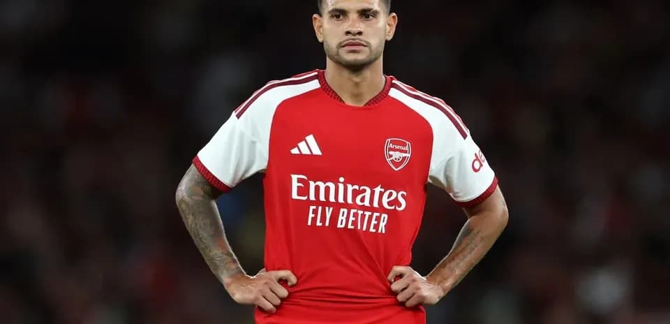 Futbolchi Arsenal futbolka kiygan, maydonda turibdi