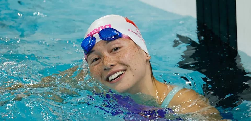Swaning swimmer smiling in pool with goggles