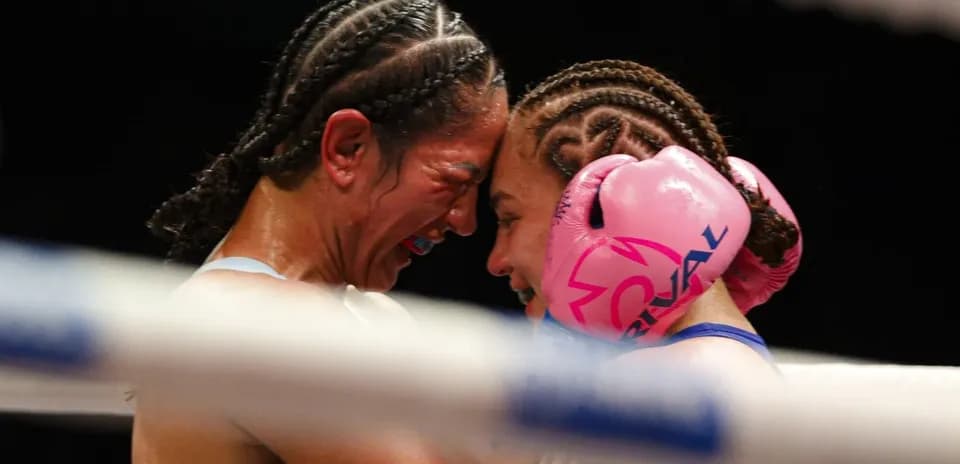 Two female boxers embracing in the ring