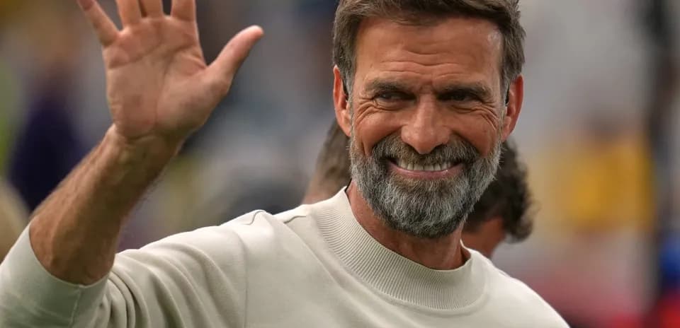 Shaggy-haired man waving during an event
