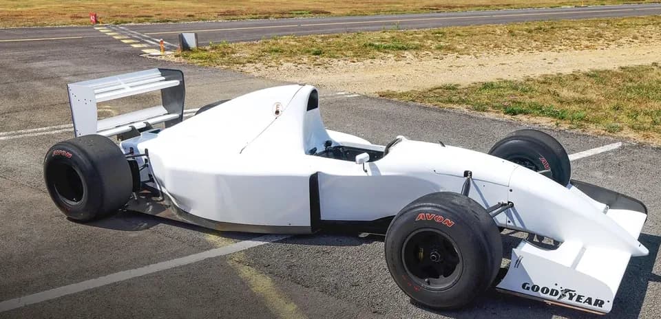 White race car parked on tarmac at airfield