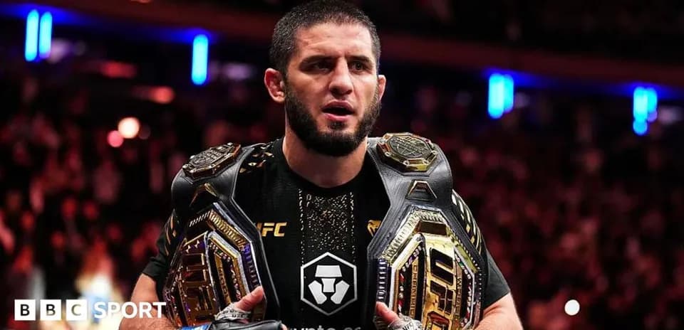 UFC champion holding two championship belts