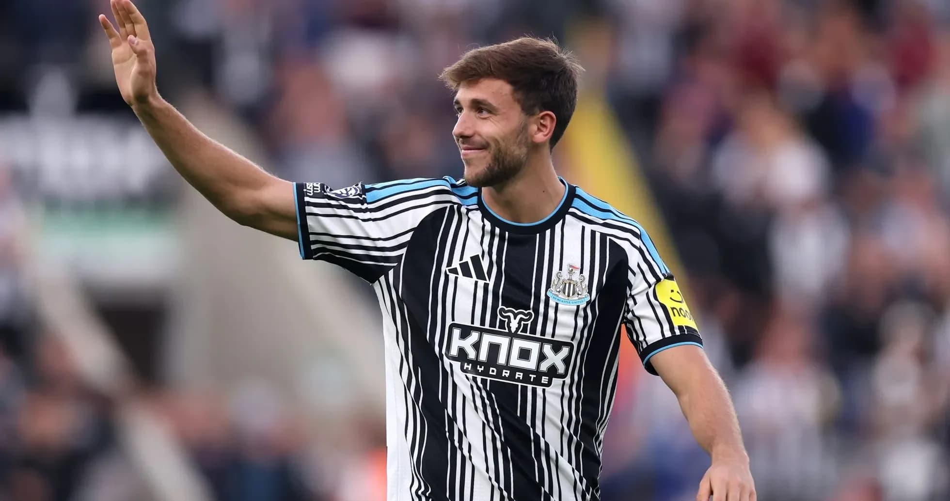 Futbolchi maydonda qo'lini ko'tarib salom berayapti