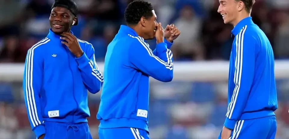 Three players in blue tracksuits during warm-up