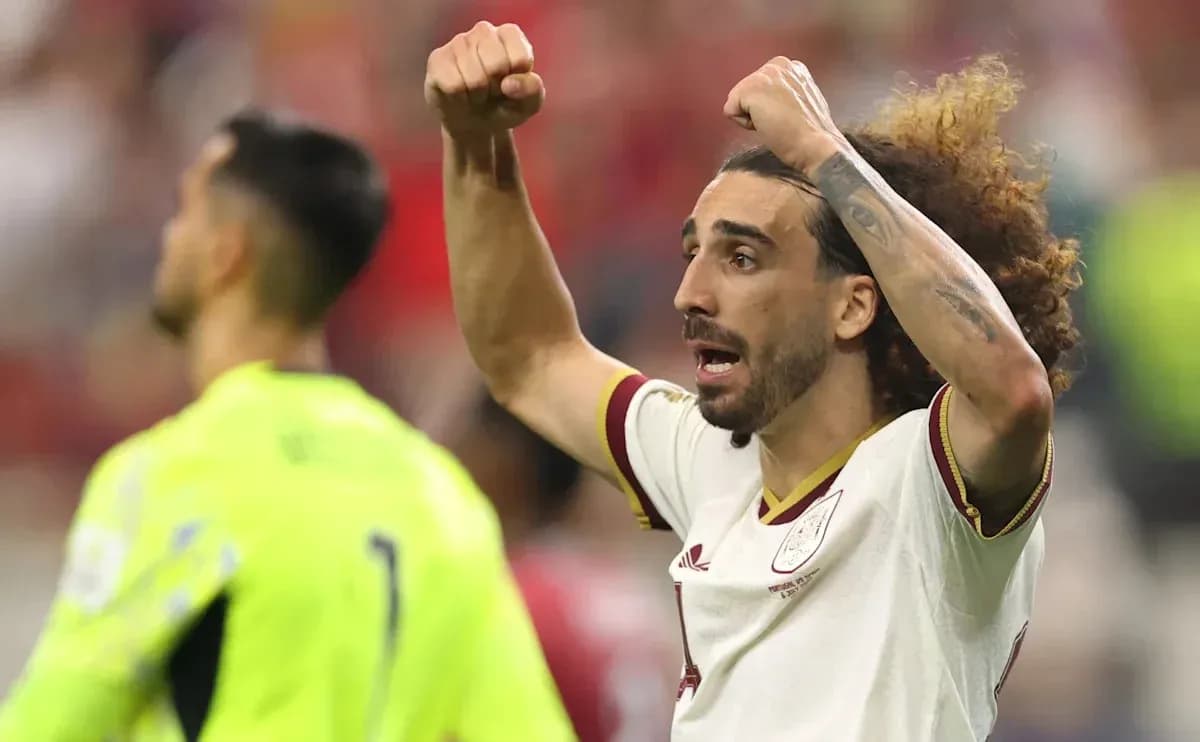 Futbolchi maydonda qo'llarini ko'tarib xursandchilik qilmoqda