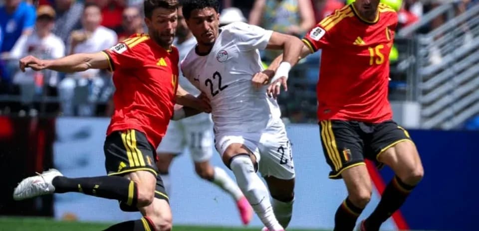 Egyptian player tackled by two Belgian defenders