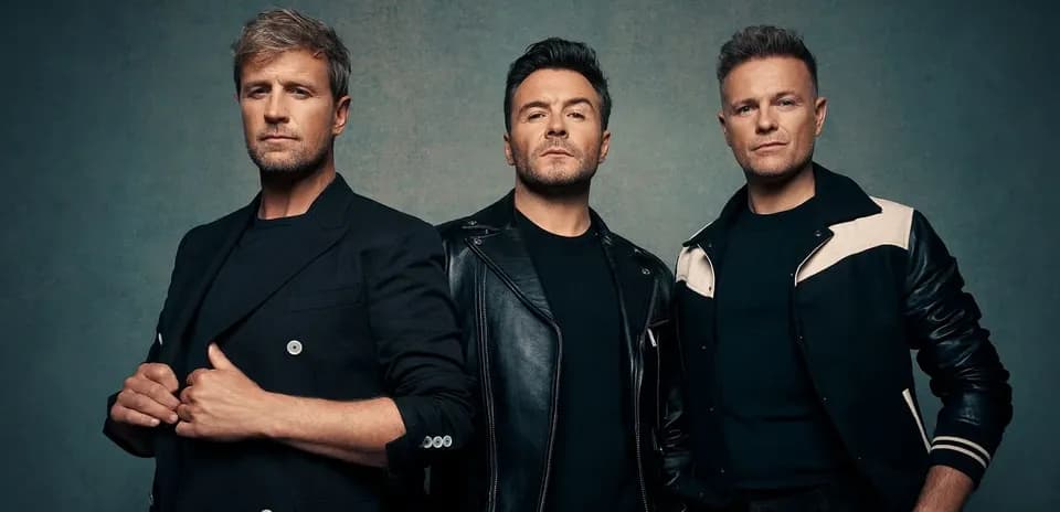 Three men posing together against a textured backdrop
