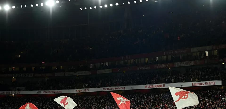 Arsenal fans waving flags in the stadium