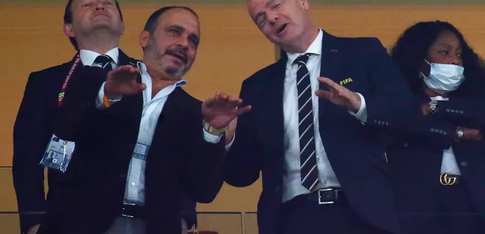 Two officials talking in a stadium box