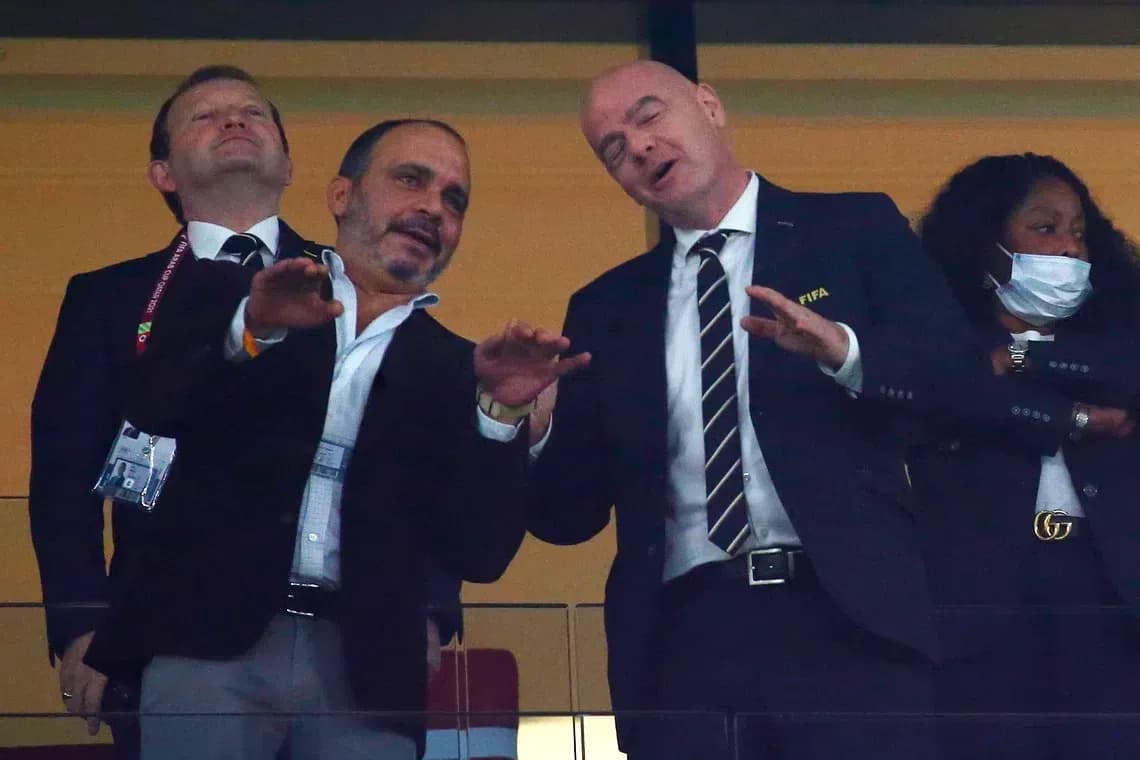 Two officials talking in a stadium box