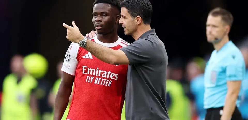 Mikel Arteta discussing strategy with Bukayo Saka