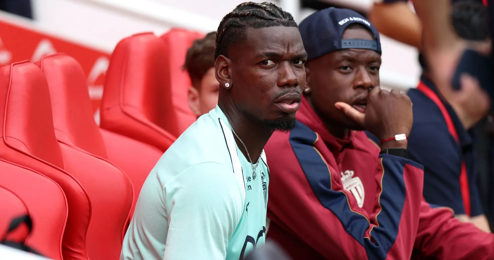 Two players seated on red benches during match