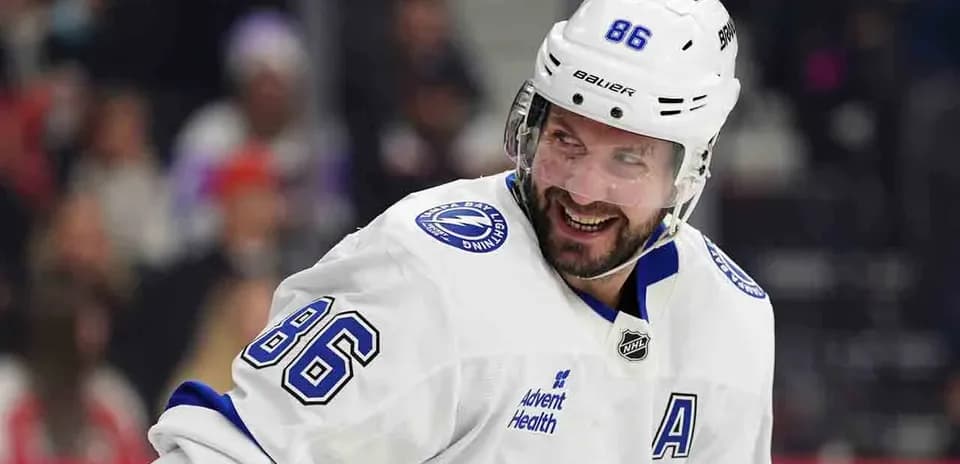 Hockey player in white uniform smiling on ice