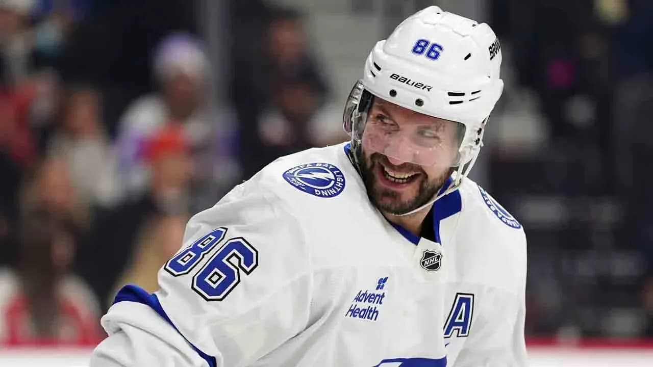 Hockey player in white uniform smiling on ice