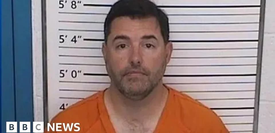 Man in orange jumpsuit in front of height chart