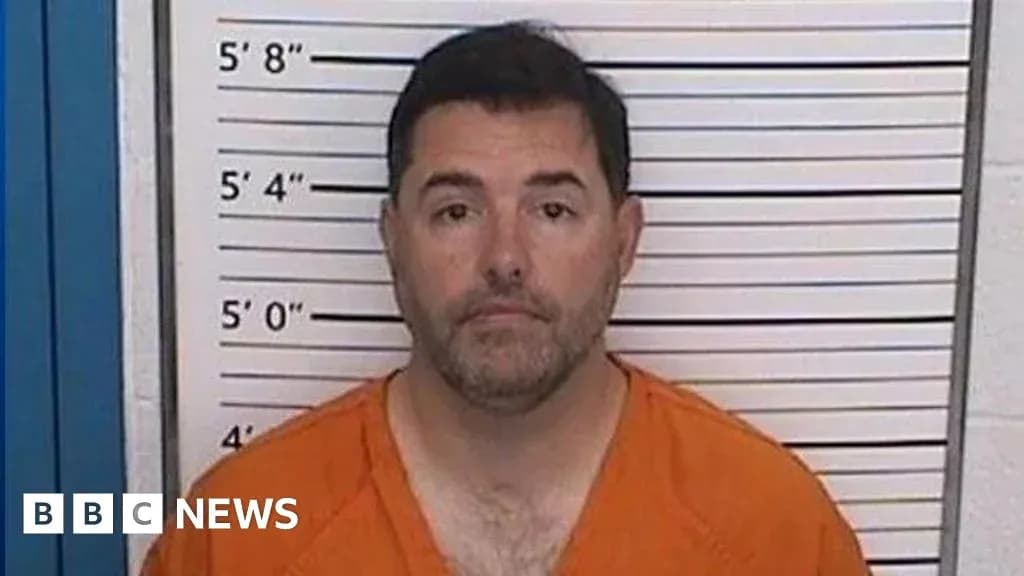 Man in orange jumpsuit in front of height chart