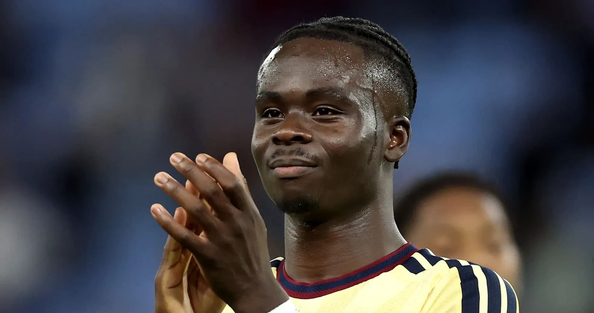 Futbolchi qo'llarini tepaga ko'tarib maqtamoqda