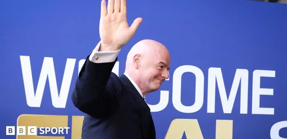 Man waving at event with welcome banner behind