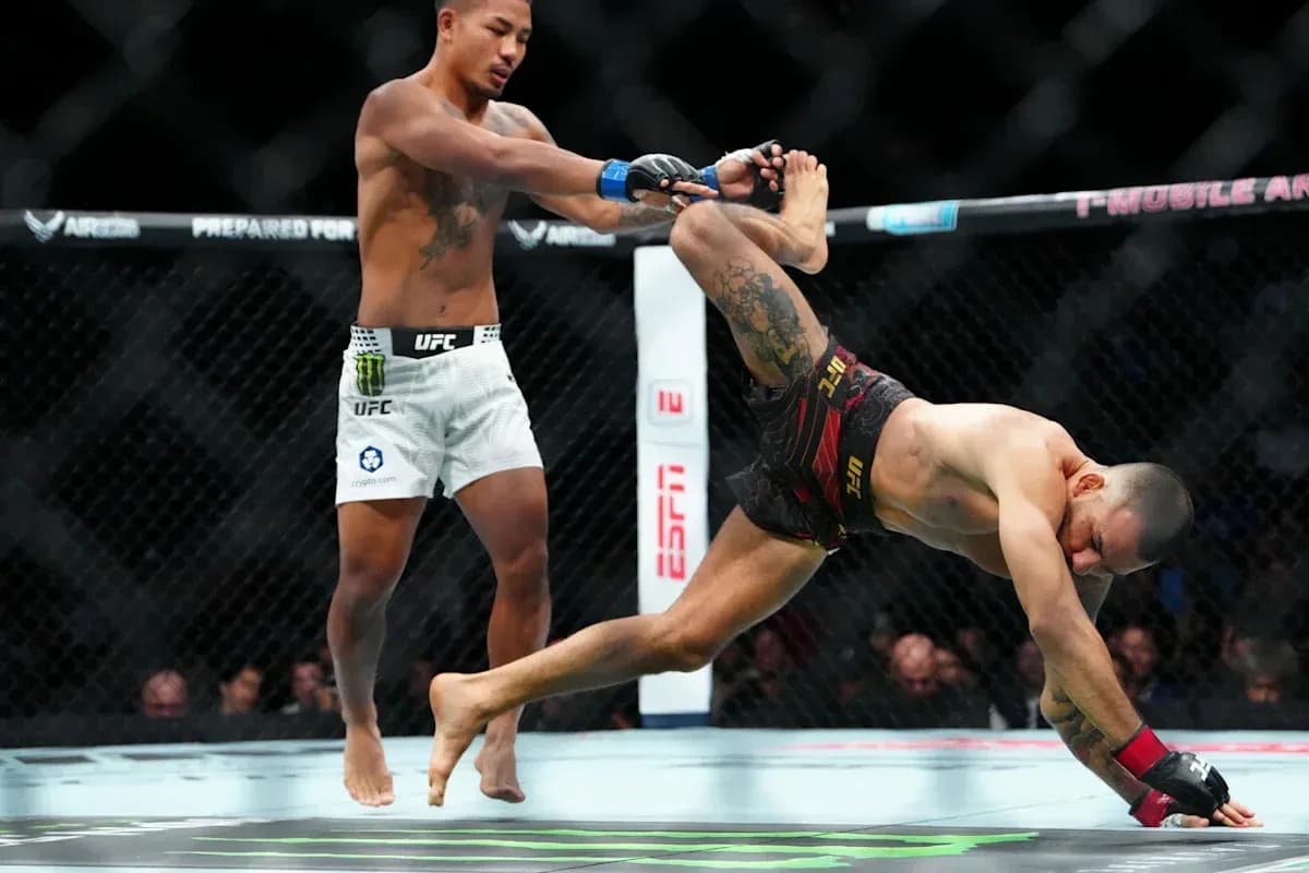 Two fighters engaged in an MMA match in octagon