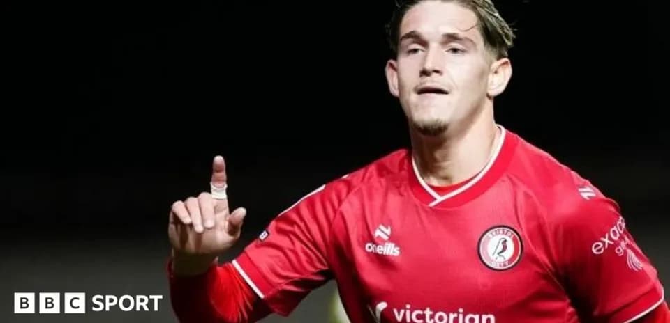 Futbolchi goli nishonlayotgan qizil forma kiygan