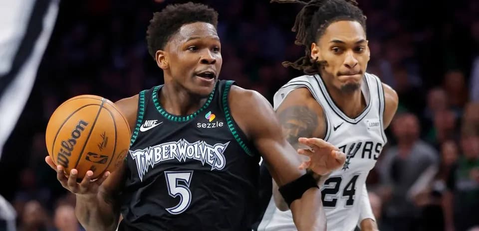 Timberwolves player dribbling past Spurs defender
