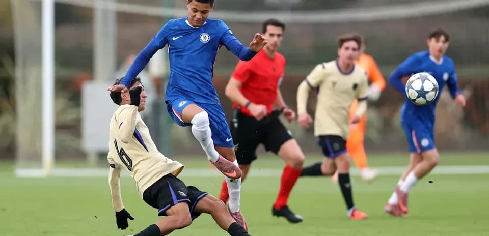 Player tackling opponent during youth football match