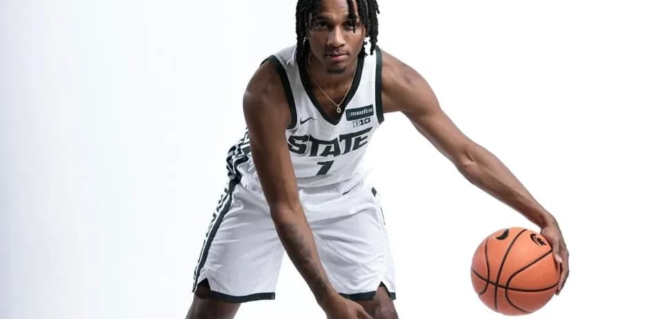 Basketball player dribbling with ball in uniform