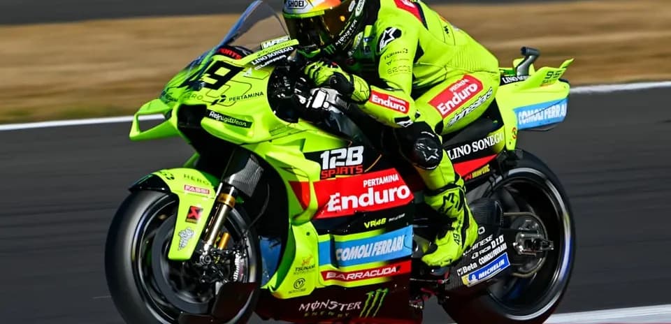 Motocyclist racing on green bike during competition
