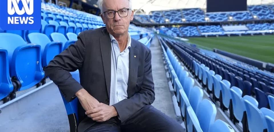 Man seated in empty stadium seats
