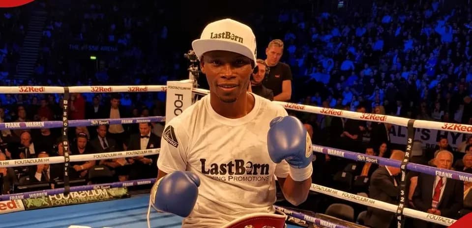 Boxer posing with gloves and championship belt in ring
