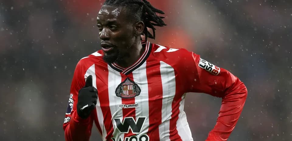 Futbolchi raqibga qarshi harakatda, yomg'irda
