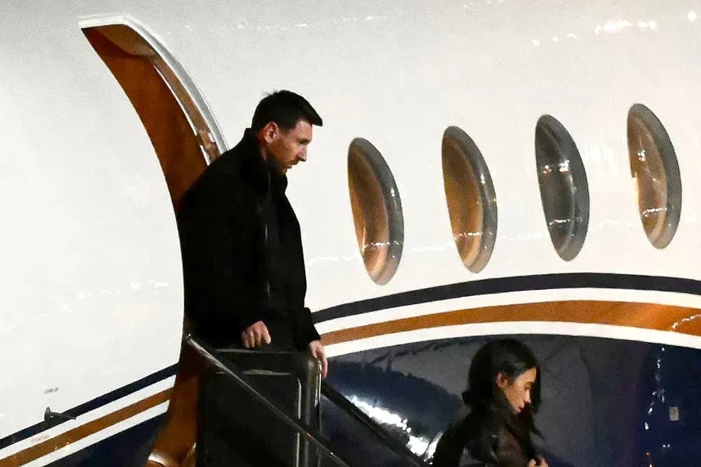 Lionel Messi exiting private jet with companion