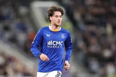 Futbolchi maydonda yugurayotgan ko'k formadagi