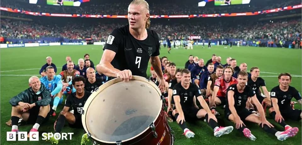 Haaland playing drum with teammates celebrating victory
