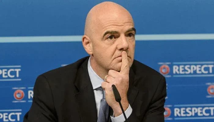 FIFA president at press conference with thoughtful expression