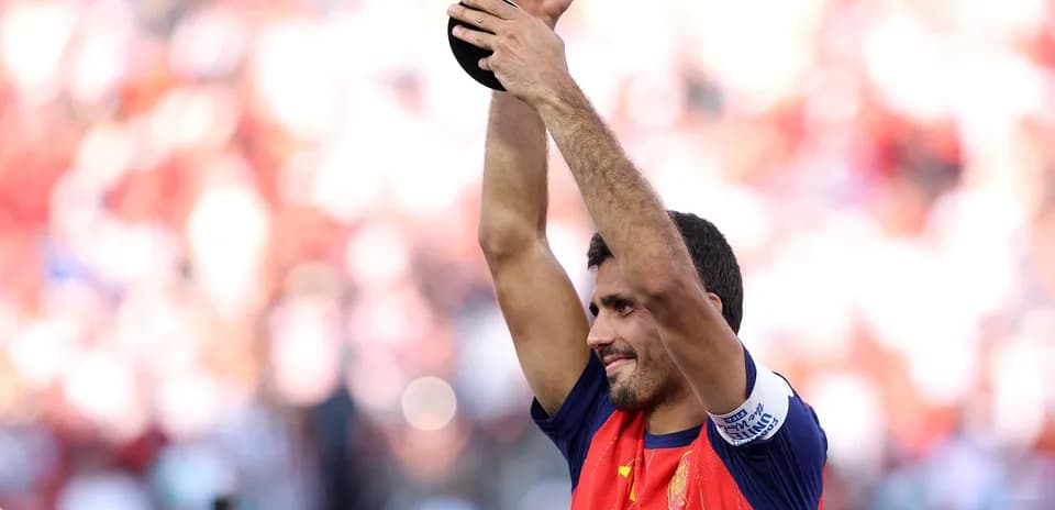Futbolchi kubokni ushlab turgan holda