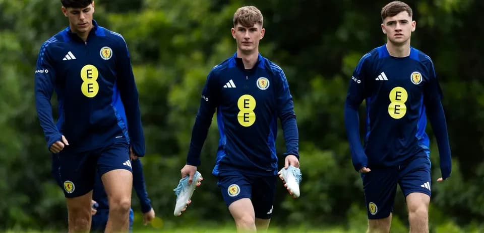 Three players walking in training gear on field