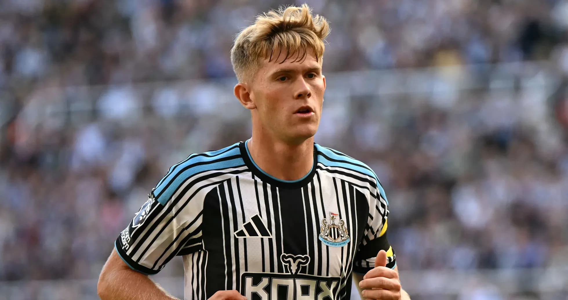 Futbolchi Newcastle United formasida maydonda yugurmoqda