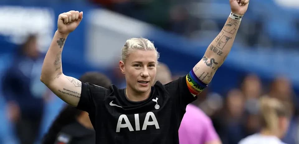 Futbolchi g'alaba uchun qo'llarini ko'tarib turibdi