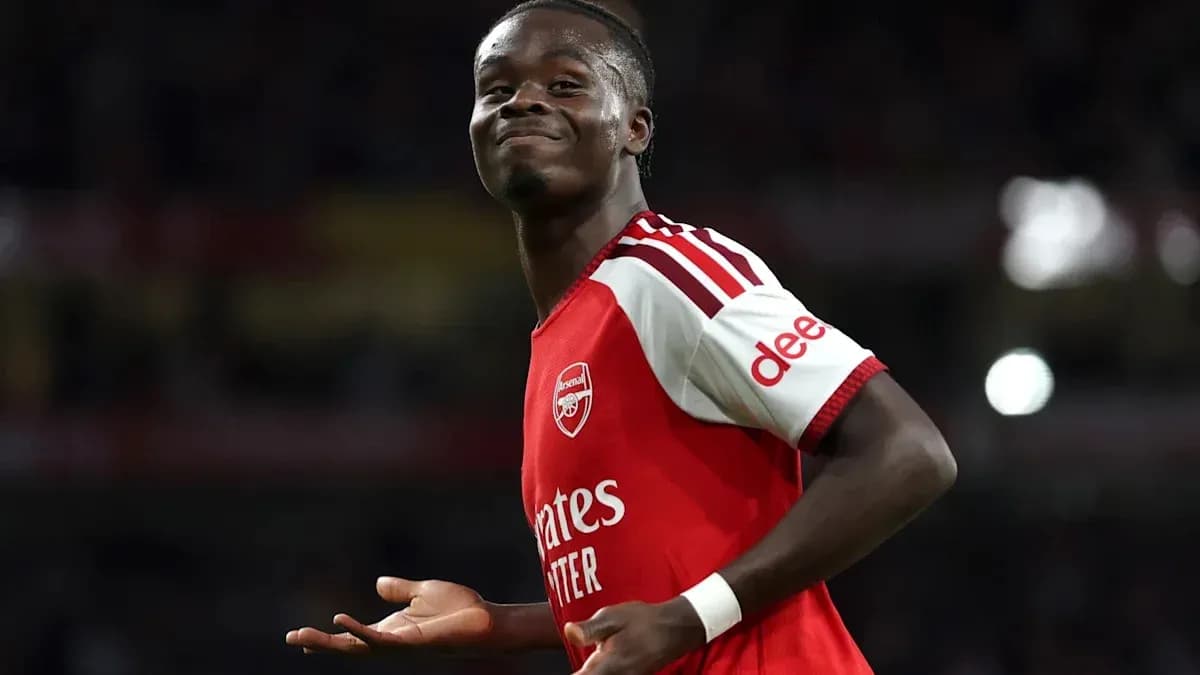 Futbolchi Arsenal futbolka kiygan, xursand ko'rinmoqda