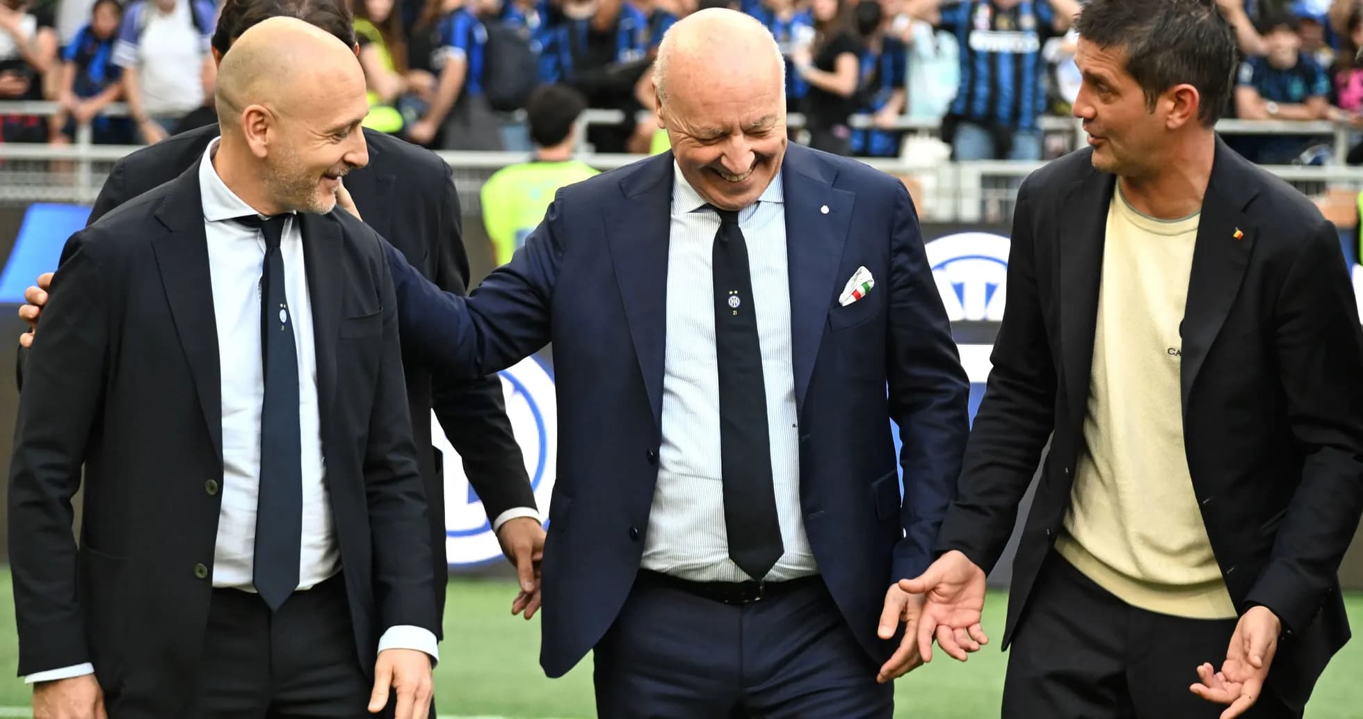 Coaches interacting on the field before match