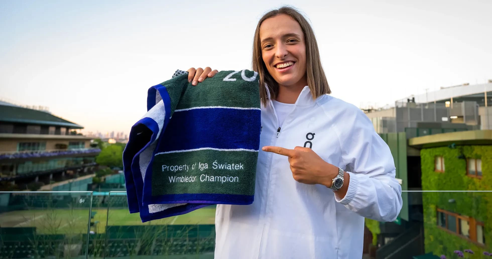 Iga Swiatek holding Wimbledon champion towel
