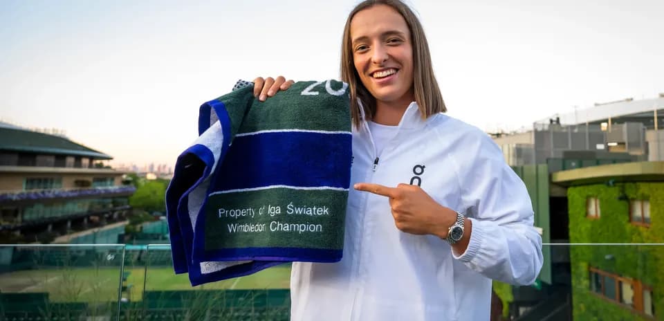 Iga Swiatek holding Wimbledon champion towel