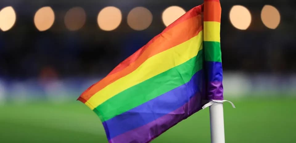 Rainbow flag on corner flag at football match