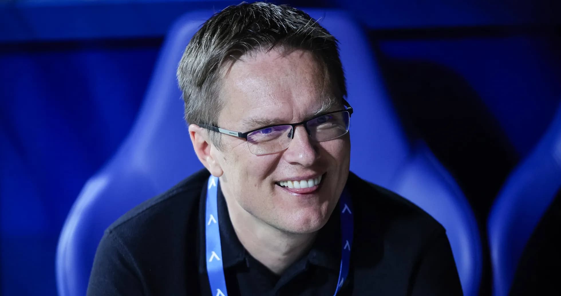 Smiling man seated in a sports venue