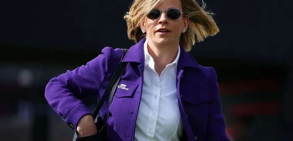 Woman in purple jacket walking with handbag
