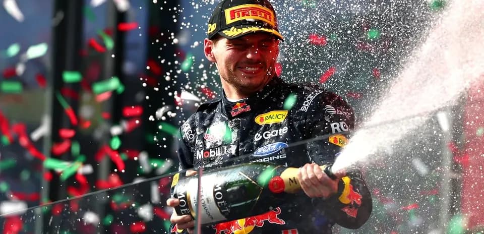 F1 driver celebrating with champagne on podium