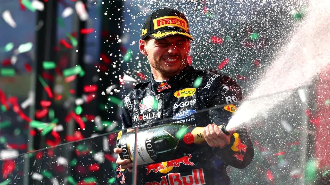 F1 driver celebrating with champagne on podium