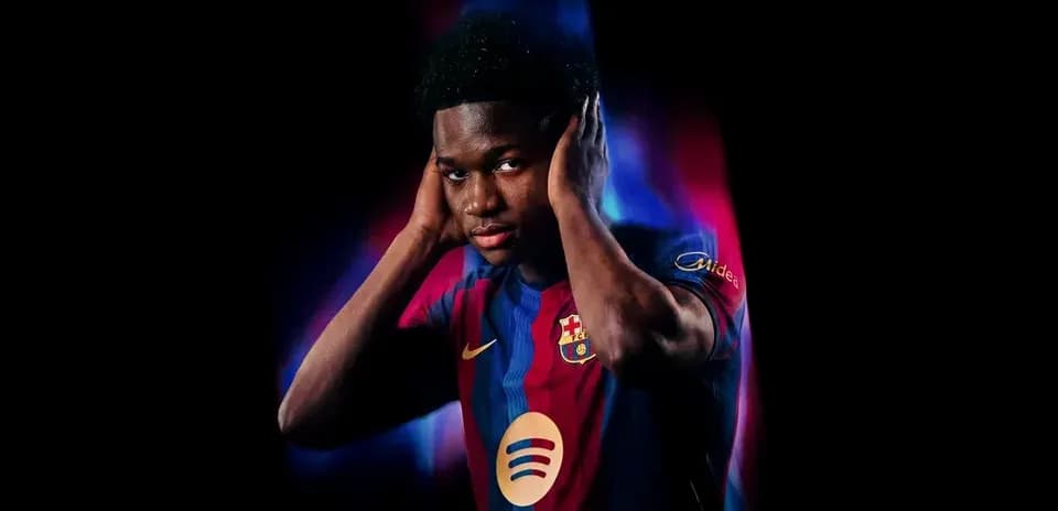 Futbolchi Barcelona formasida, quloqlarini yopgan
